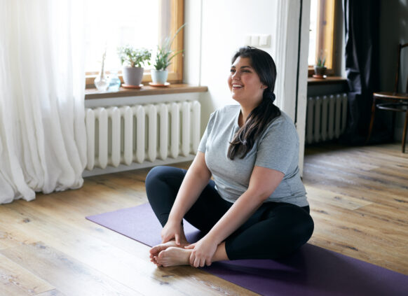 Glückliche Junge Frau auf Yoga Matte