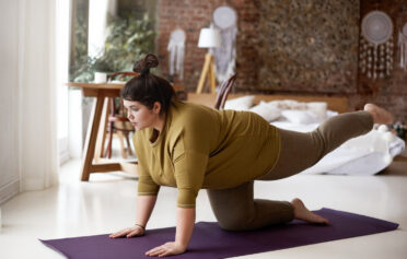 Junge übergewichtige Frau macht Yoga