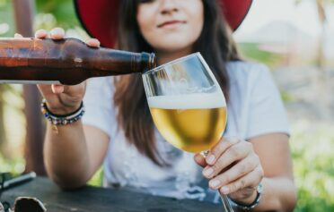 Frau trinkt ein Bier.