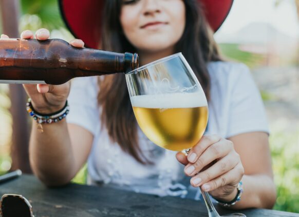 Frau trinkt ein Bier.