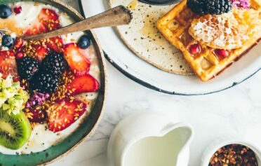 gedeckter Frühstückstisch mit süßem Frühstück