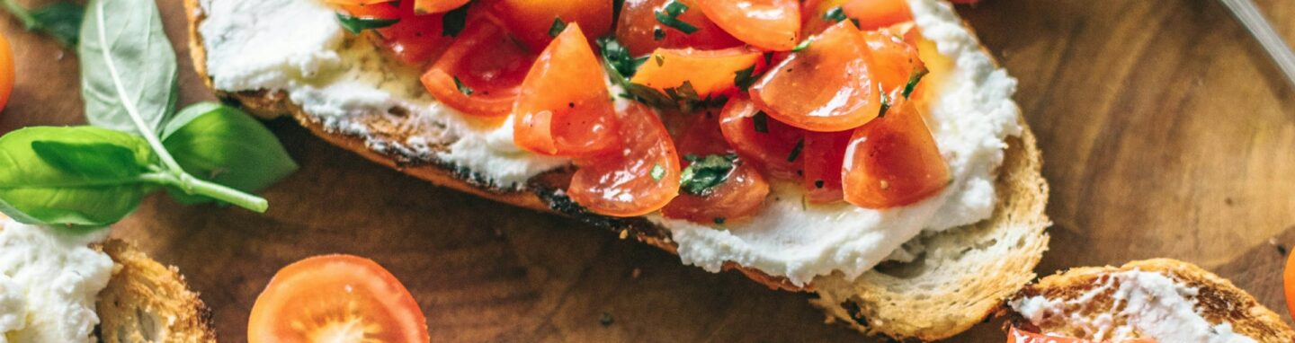 Tomatenbrot mit Olivenöl auf einem Brett.