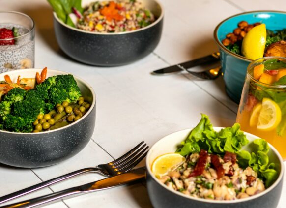 Verschiedene Bowls mit Gemüse stehen auf einem gedeckten Tisch.