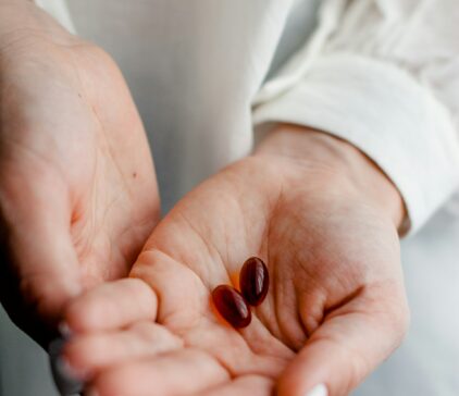 In der Hand sind zwei Supplement Tabletten.