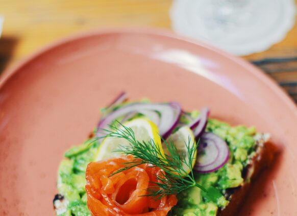 Ein eine Scheibe Brot mit Guacamole, Lachs und Zwiebeln.