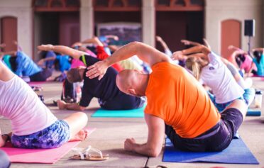 Eine Gruppe von Männern und Frauen macht gemeinsam Yoga und isometrische Übungen.