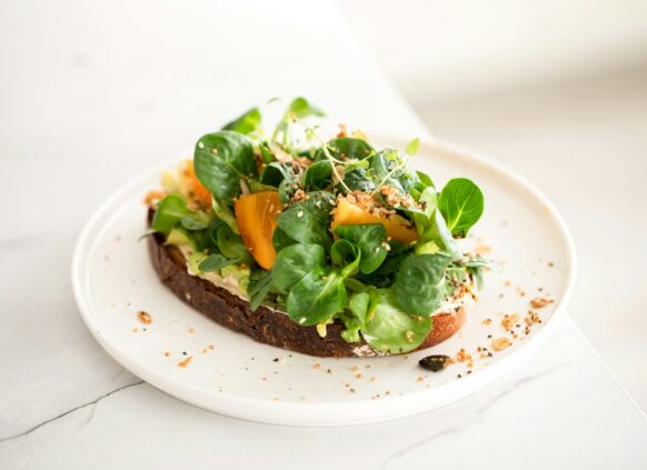 Ein frisches Brot belegt mit Avocado und Feldsalat.