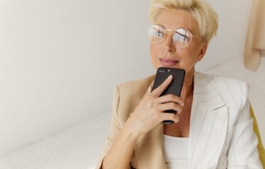 Eine Frau in den Wechseljahren sitzt mit ihrem Handy