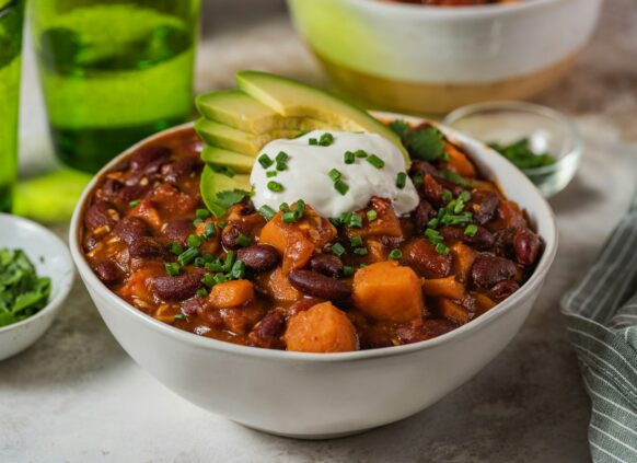 Eine Schüssel mit Chili con Carne getoppt mit Sour Cream und Avocado.