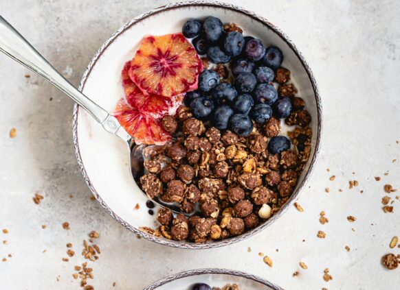 Zwei Joghurtbowls mit Granola und frischen Beeren.