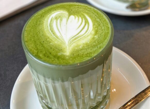 Zwei Gläser Matcha Latte auf einem Tisch im Cafe.