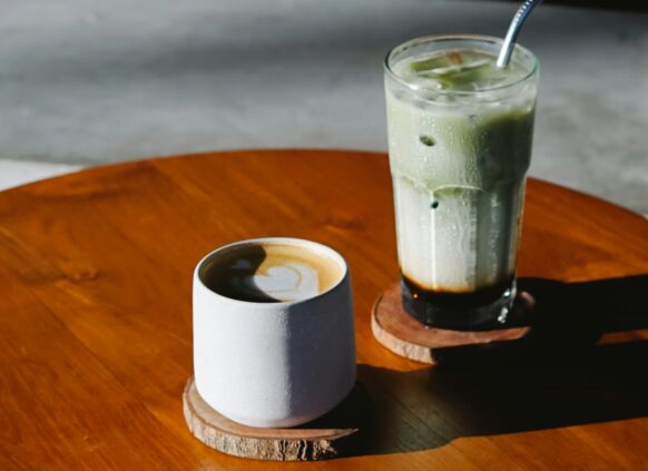 Eine Tasse Kaffee und ein Glas Matcha Latte auf einem Tisch.