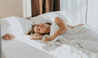 Eine Frau liegt auf der Seite schlafend im Bett.