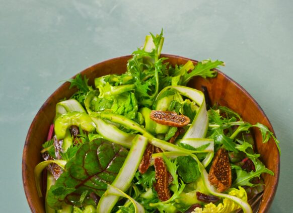 Eine Schüssel mit grünem Löwenzahnsalat mit vielen Bitterstoffen.