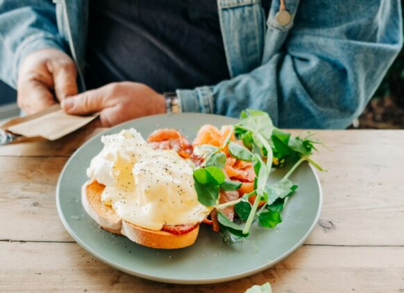 Ein Brot mit Lachs und Spiegelei mit Salatbeilage.