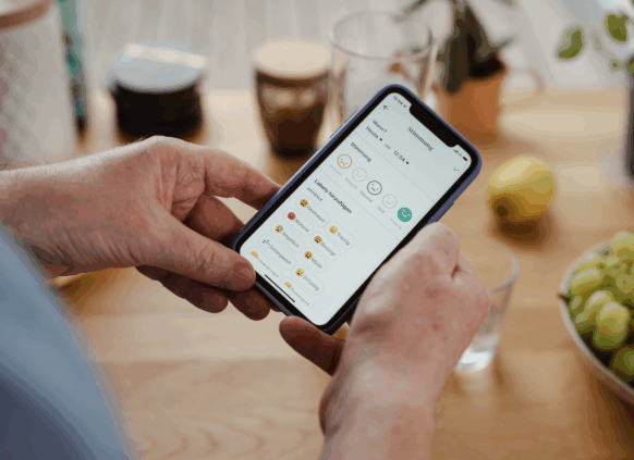 zwei Hände halten ein Handy, auf welchem die Oviva App geöffnet ist