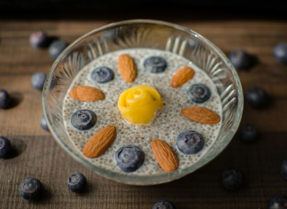Eine Schale mit Chiapudding, Nüssen und Blaubeeren.