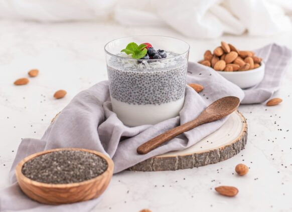 Ein Glas Chia-Hafer-Brei mit Nüssen und Obst.