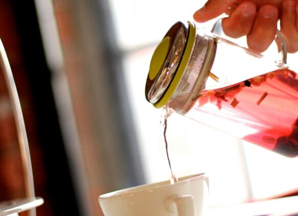 Früchtetee, der in Tasse gegossen wird