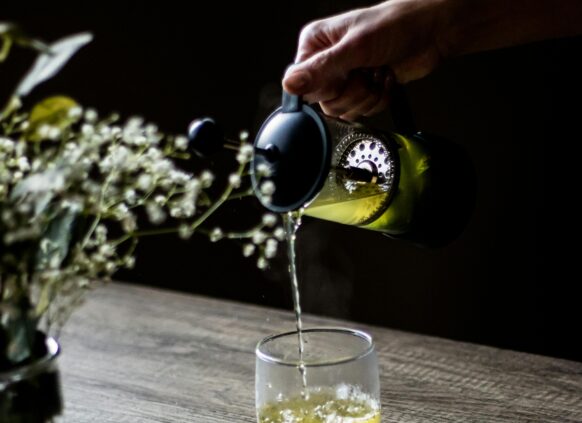 Grüner Tee, der in Glas gegossen wird