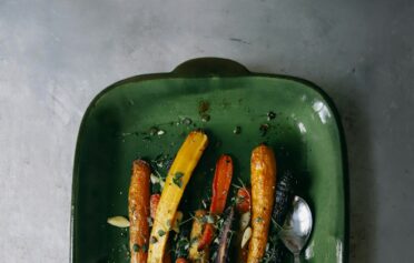 Eine Auflaufform mit gebackenen bunten Karotten aus dem Ofen.