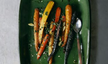 Eine Auflaufform mit gebackenen bunten Karotten aus dem Ofen.