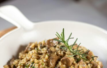 Eine Pfanne mit braunem Reis-Pilz Risotto.