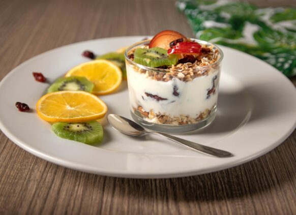 Eine Schale Joghurt mit Granola Müsli und frischem Obst.