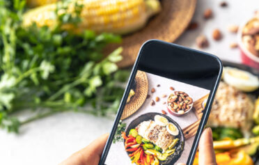 Ein Auschniit eines Handydisplays, auf dem ein Foto von einem leckeren Essen gemacht wird.