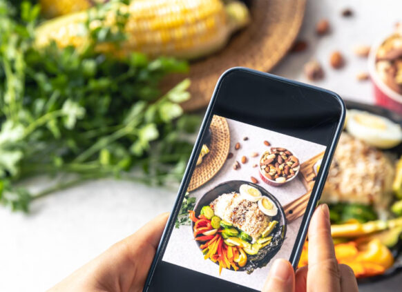 Ein Auschniit eines Handydisplays, auf dem ein Foto von einem leckeren Essen gemacht wird.