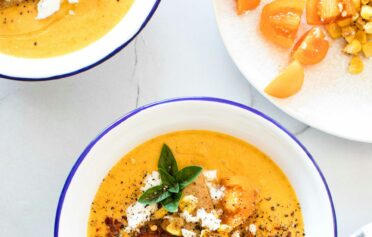 Eine Schale mit Kürbissuppe getoppt mit Kürbiskernen und Feta.