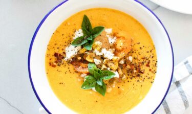 Eine Schale mit Kürbissuppe getoppt mit Kürbiskernen und Feta.