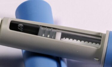 Eine Nahaufnahme einer Anehmspritze, die offen auf der Kappe der Nadel liegt.