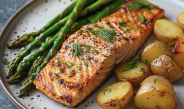 Gegrillter Lachs auf einem Teller mit Spargel und Ofenkartoffeln