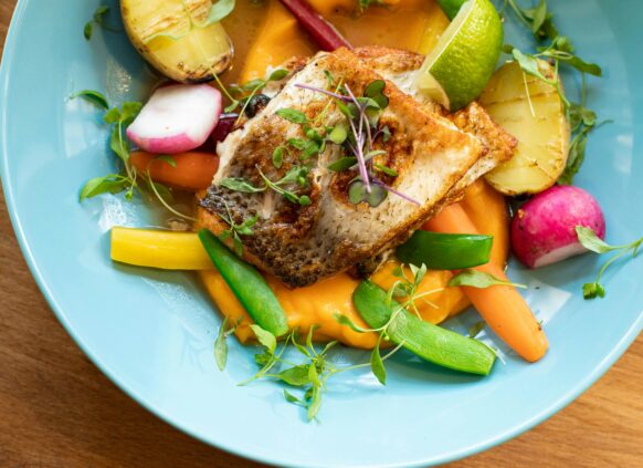 eine bowl mit frisch gebratenem fisch und gemüse