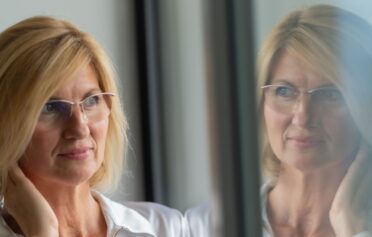 ältere Frau spiegelt sich im Fenster