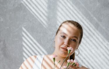 Frau mit Blumen schaut in die Kamera