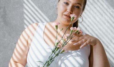 Frau mit Blumen schaut in die Kamera