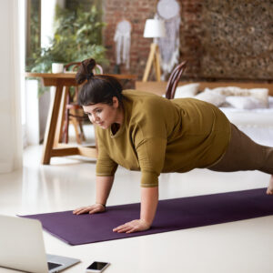 Junge Frau macht Sport auf Yogamatte