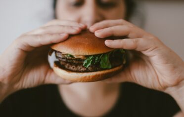 Frau isst Burger ohne Hunder
