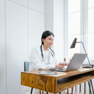 Ärztin sitzt am Schreibtisch