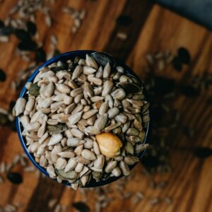 gesunde Nüsse und Samen im Glas auf Holzbrett