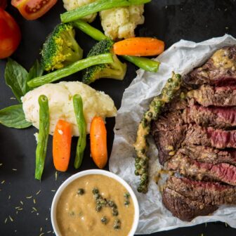 Gemüse und Fleisch als eiweißreiche Ernährung auf einer schwarzen Platte