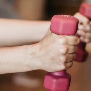 Hände halten rosa Hanteln