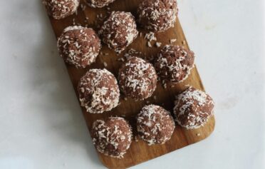 Gesunde Energyballs auf einem Holzbrett.