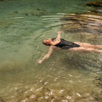 Frau liegt im Wasser und ist glücklich und zufrieden