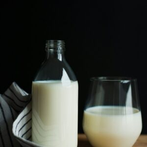Eine Glasflasche und ein Glas befüllt mit Milch.