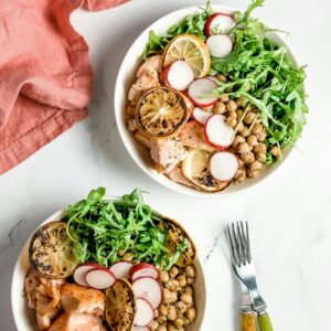 Zwei Teller befüllt mir gegrilltem Lachs, Salat und Hülsenfrüchten als kaliumreiche Lebensmittel.