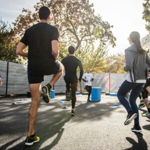 Eine Gruppe aus Männern und Frauen macht gemeinsam draußen ein Workout.