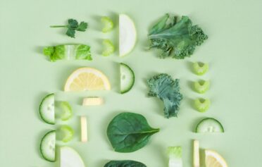 Gesundes Obst und Gemüse auf grünem Hintergrund